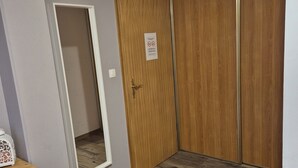 A room with a wooden wardrobe, a mirror, and a wooden table. - Chambres Thirion (Saint-Hippolyte)