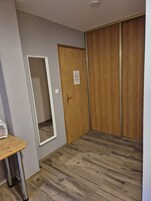 Una habitación con un armario de madera, un espejo y una mesa de madera.