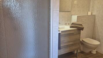 A bathroom with a shower, toilet, and sink.