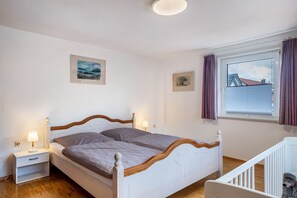 Una camera da letto con un letto, un comodino e una culla.