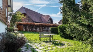 A stone pathway leading to a bench in a well-maintained garden with a house in the background. - Apartment '85qm, 2 Schlafzimmer' with Mountain View, Private Terrace and Wi-Fi (St. Märgen)