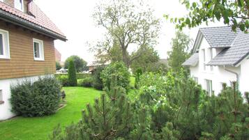A residential area with houses, a well-maintained lawn, and a variety of trees.