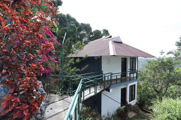 A two-story building with a balcony and a staircase leading to the upper floor.