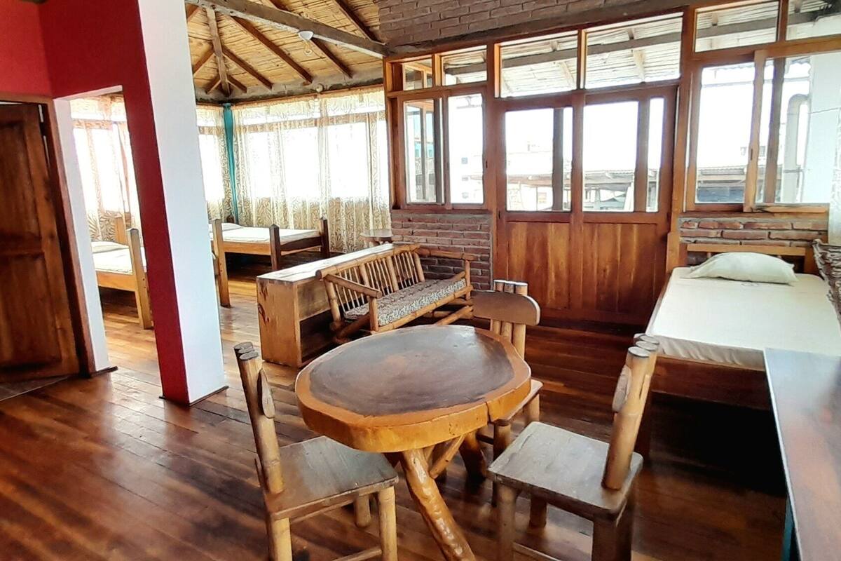 Una habitación con muebles de madera, una mesa redonda y una cama con cabecero.