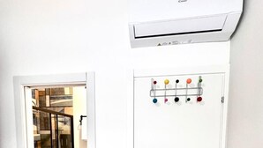 A white air conditioning unit mounted on a wall with a control panel featuring multiple colored buttons. - Confort room with private bath in Rome, Metro C (Roma)
