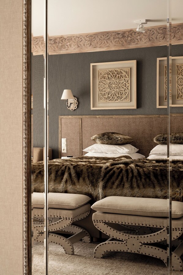 A bedroom with a bed, a nightstand, a lamp, and a decorative wall panel.