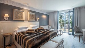 Habitación de hotel moderna con una cama grande, dos lámparas fijadas a la pared y vistas al exterior.