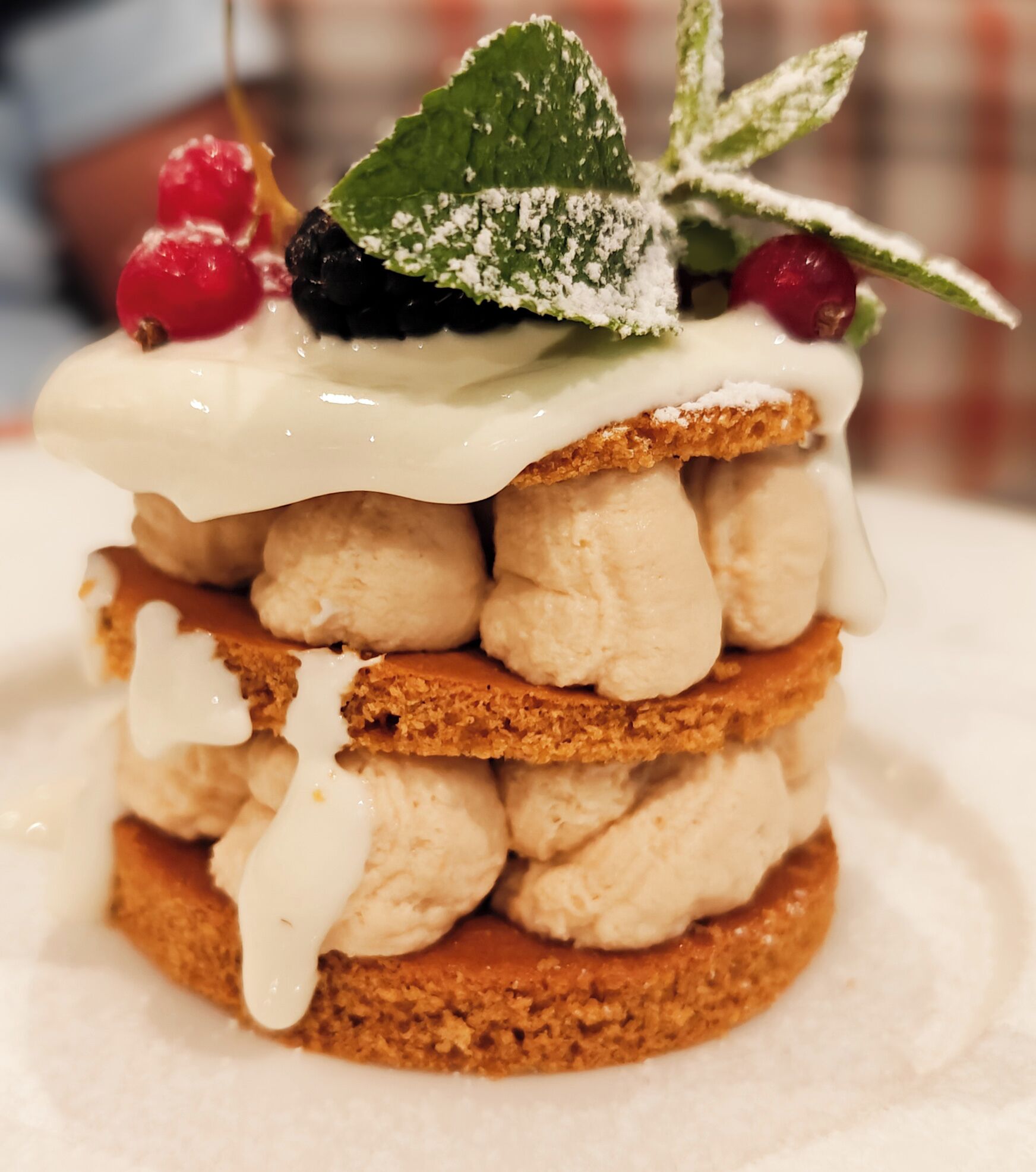 Un dessert composé de couches de gâteau, de crème glacée et de fruits rouges.