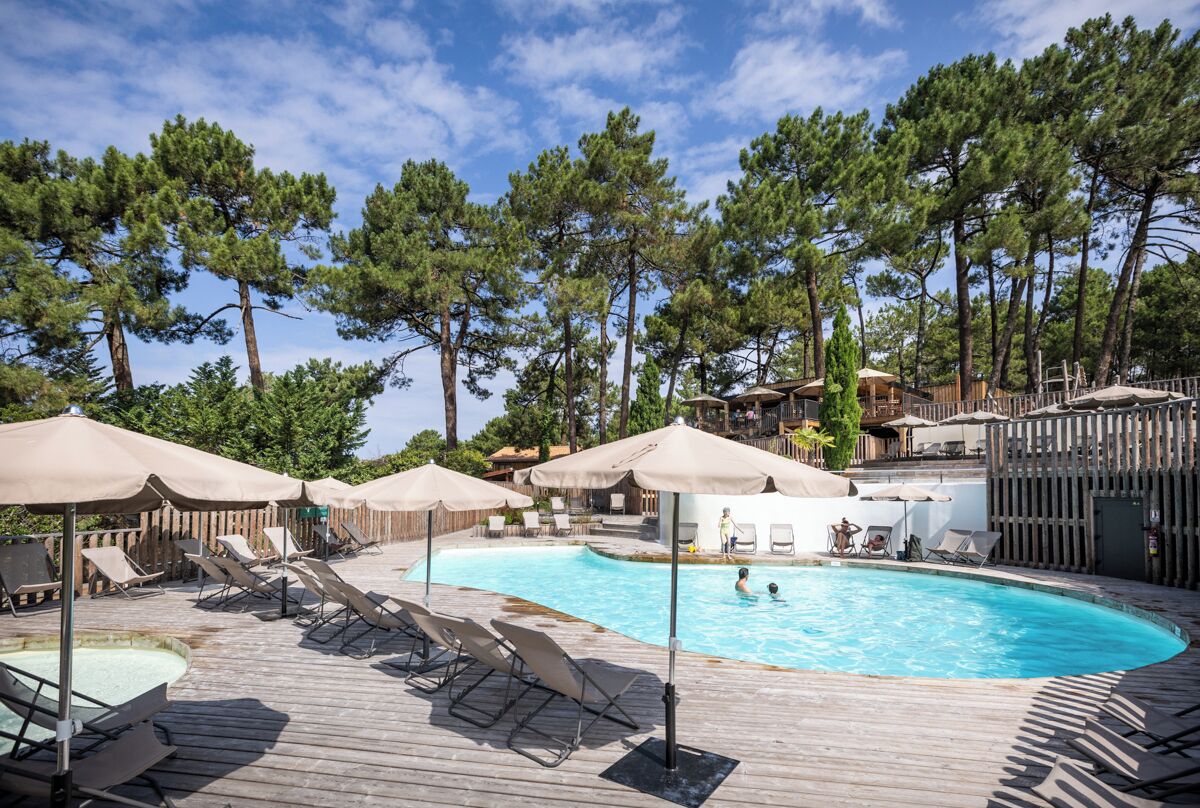 Una piscina al aire libre de temporada, sombrillas, tumbonas