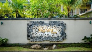A wall with a decorative sign for "Akatora Hotel" featuring a stone and metal design. - Akatara Hotel (Penida Island)