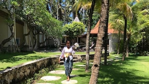 A pathway with circular stepping stones leading to a building with a tiled roof. - Akatara Hotel (Penida Island)