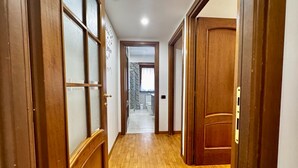 A hallway with wooden doors and a tiled floor, leading to a bathroom with a shower and toilet. - VACATION HOUSE IN OSTIA LEVANTE WITH 6 BEDS - ADJACENT LIDO NORD STATION (Lido di Ostia)