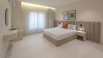 Quarto de hotel moderno com uma cama grande, mesas de cabeceira, um espelho e uma janela com cortinas.