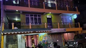 A two-story building with a ground-floor shop and a balcony on the upper floor. - benus (Darjeeling)