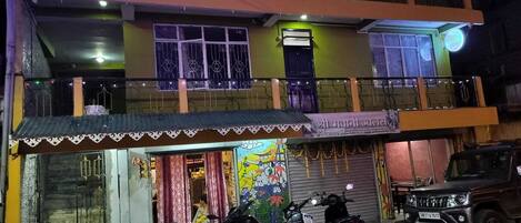 A two-story building with a ground-floor shop and a balcony on the upper floor.
