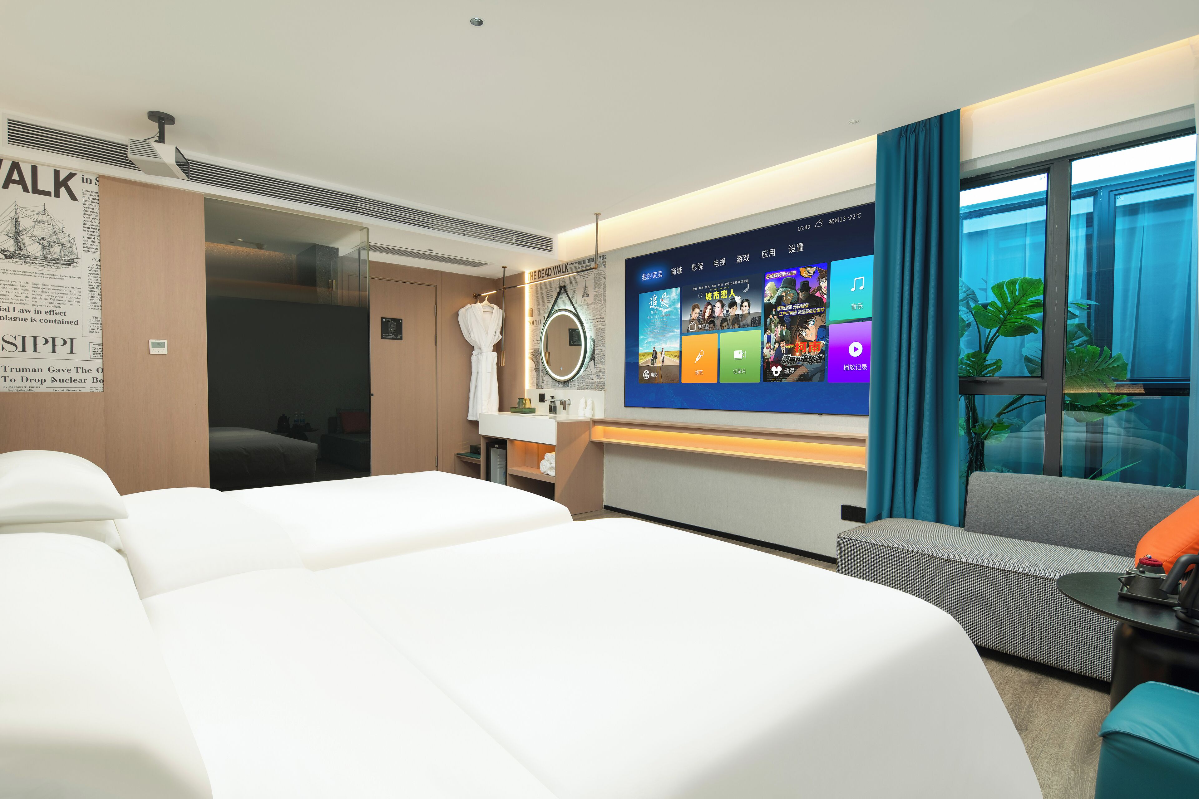 A hotel room with two beds, a TV displaying a digital interface, a mirror, a window with curtains, and a small table with a phone.