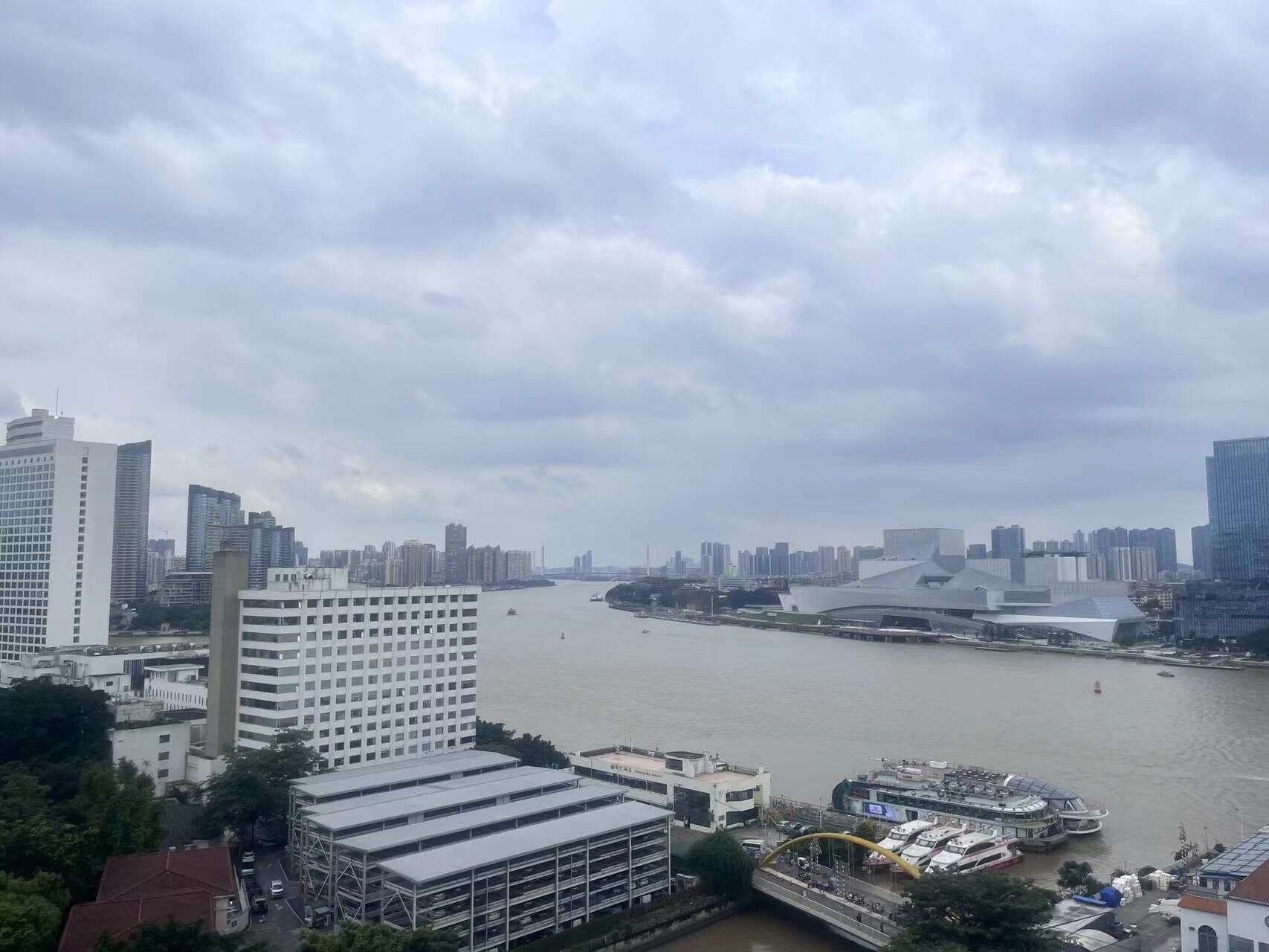 A cityscape with a river, modern buildings, and a bridge.