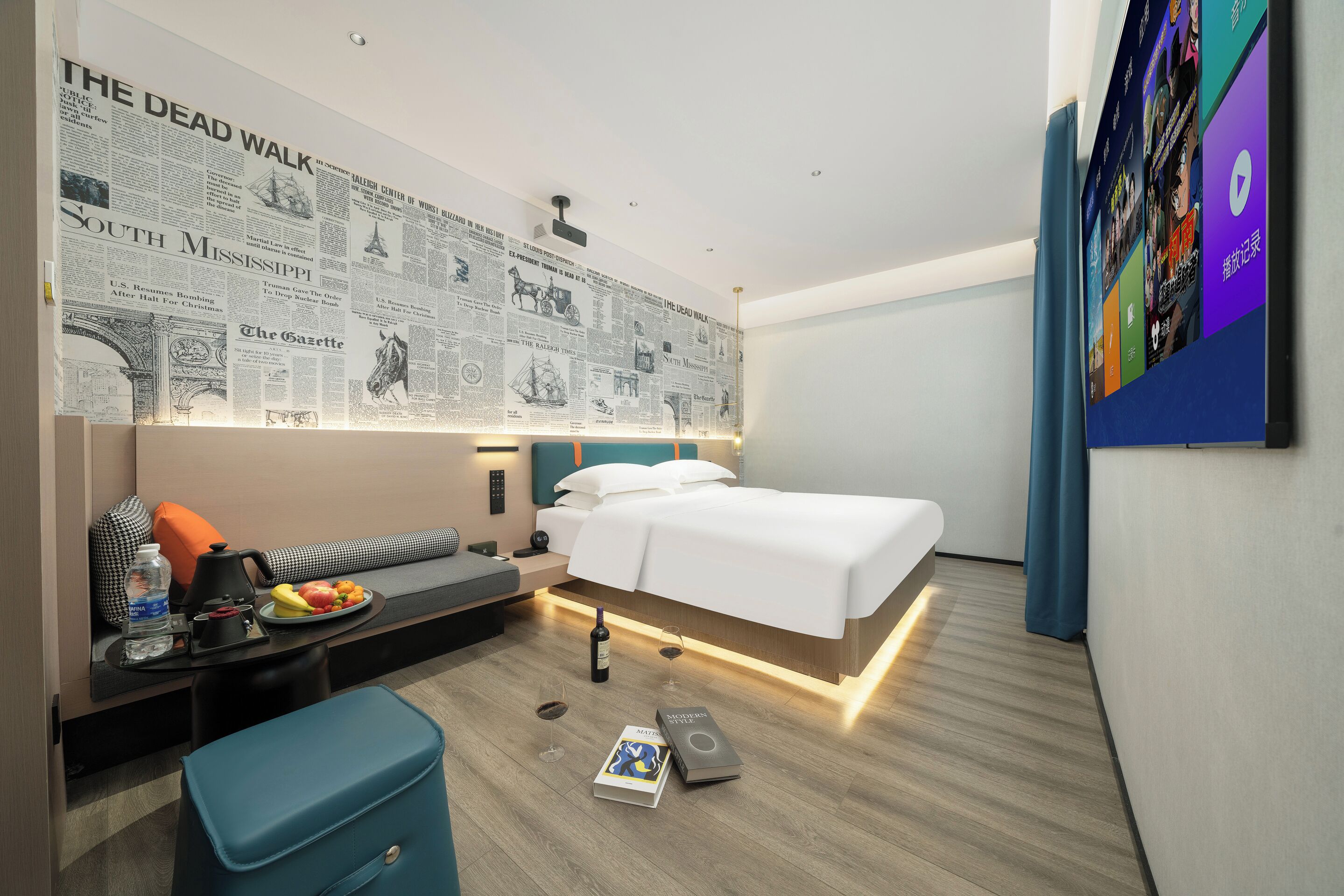 Una habitación de hotel moderna con una cama, una mesita de noche y una pared decorada con recortes de periódicos.