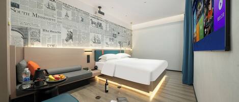 A modern hotel room with a bed, bedside table, and a wall decorated with newspaper clippings.