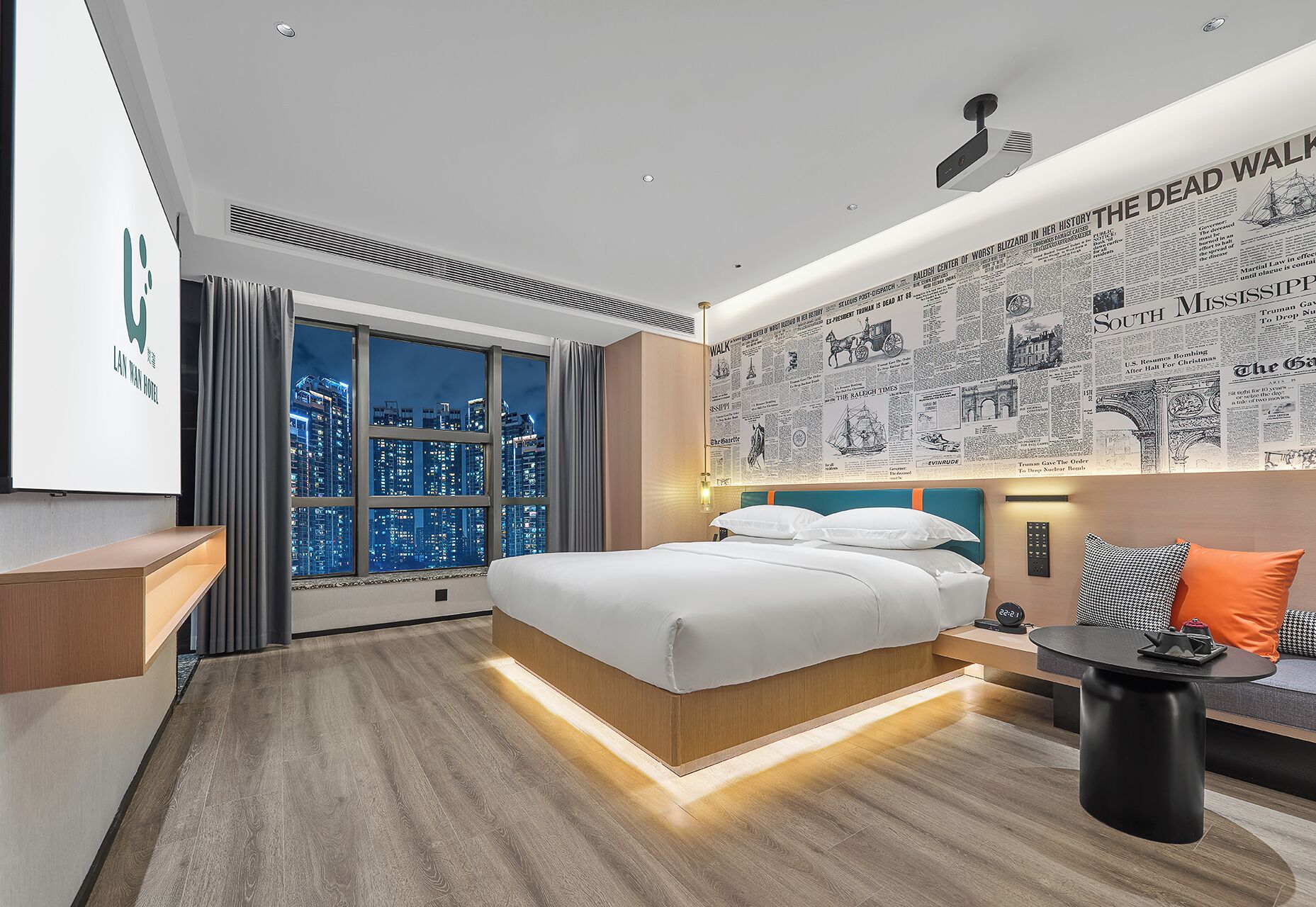 A modern hotel room with a large bed, a desk, and a city view.