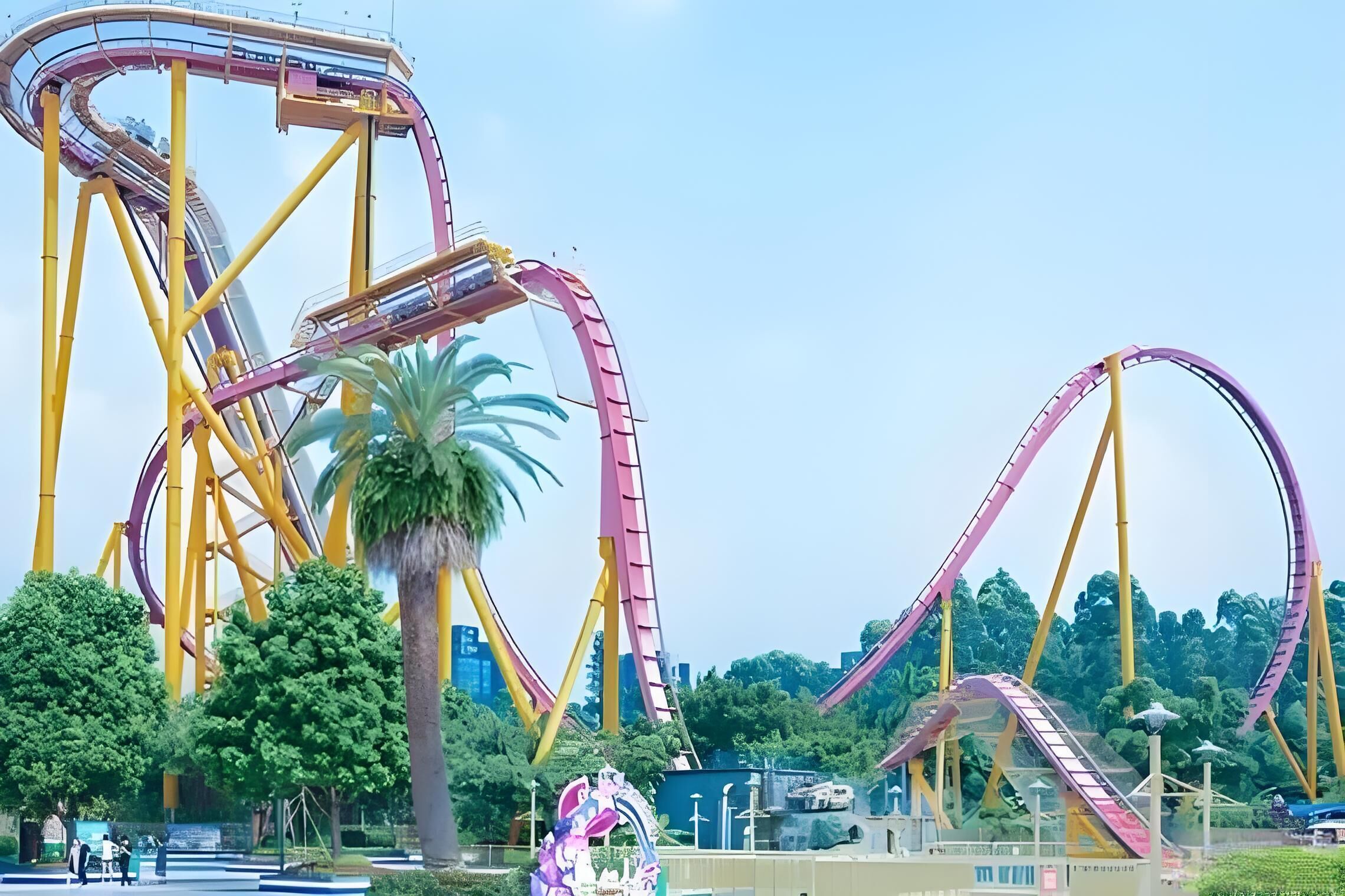 Una montaña rusa con múltiples vías y un arco decorativo grande.