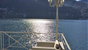 Une terrasse avec des marches menant à un plan d’eau, une rambarde et un lampadaire.