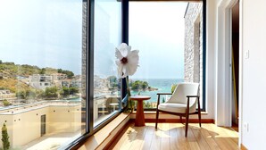 Ein Balkon mit Meerblick, einer weißen Blumendekoration und einem Stuhl.