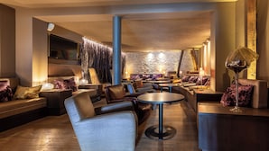 Ein stilvoller Lounge-Bereich mit Ledersofas, runden Tischen und stimmungsvoller Beleuchtung.