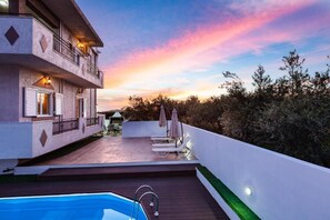 A rooftop with a swimming pool, lounge chairs, and a view of the sunset. - Villa Kounoupas (Mylopotamos)