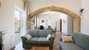 A living room with a sofa, a coffee table, and a dining area with a table and chairs.
