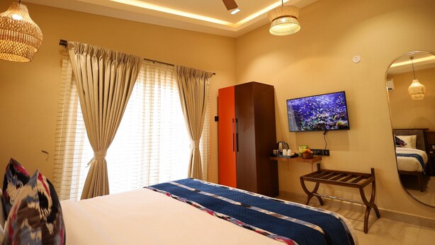 Une chambre d’hôtel équipée d’un lit, d’une télévision, d’une armoire et d’un ventilateur de plafond.