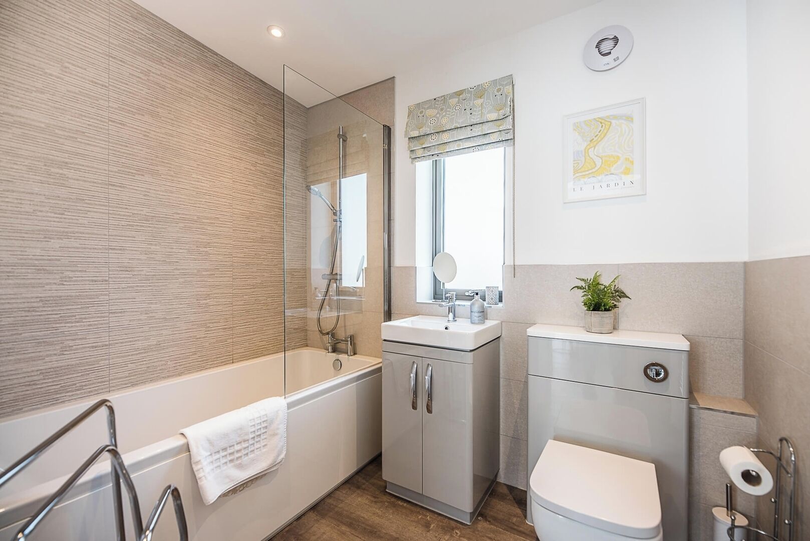 A modern bathroom with a glass-enclosed shower, a sink with a mirror, and a toilet.