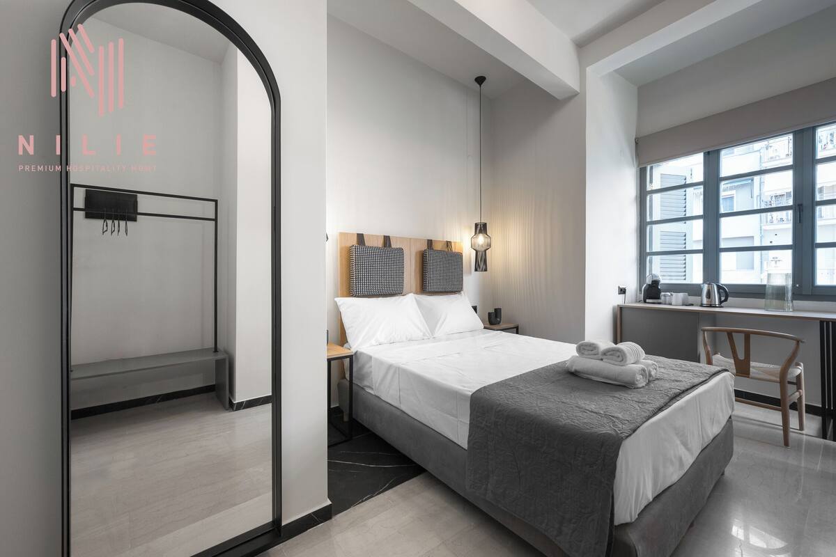 Una habitación de hotel moderna con una cama grande, un escritorio y una ventana.