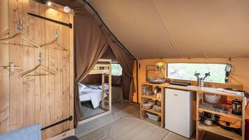 Interior compacto de autocaravana con kitchenette, cama y comedor.