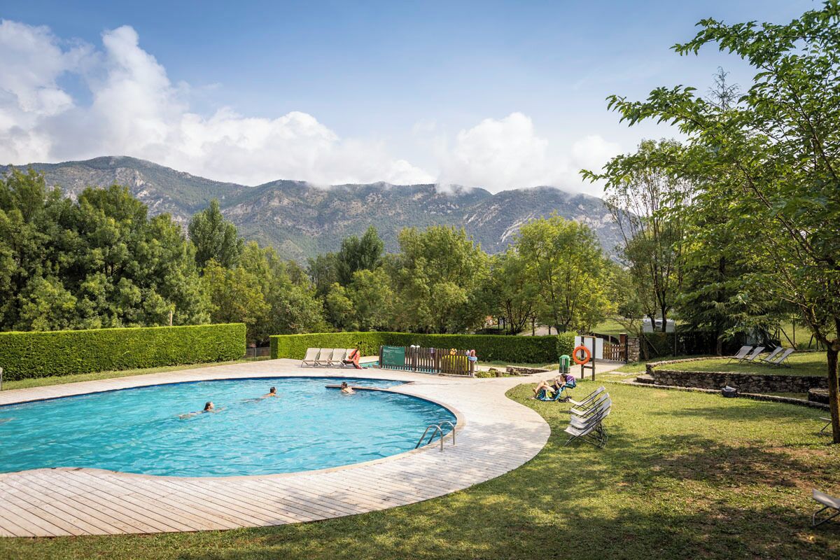 Una piscina al aire libre de temporada, sombrillas