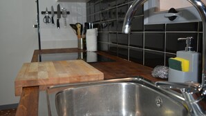 A kitchen with a stainless steel sink, wooden countertop, and a cutting board. - Family Apartment near ADDA | Breakfast Included | Sleeps 7 (Alicante (Alacant))