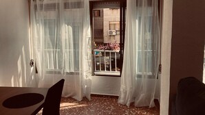 A room with a window, a door, a table, and a chair. - Family Apartment near ADDA | Breakfast Included | Sleeps 7 (Alicante (Alacant))