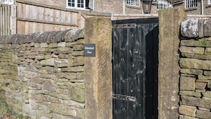 A stone wall with a black gate and a sign reading "Oakenbank Barn". - Oakenbank Barn (Macclesfield)