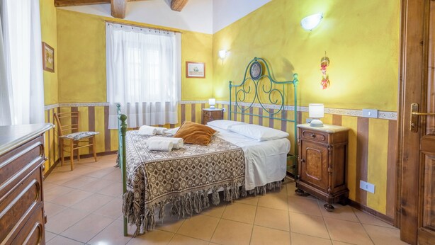 A bedroom with a bed, wooden dresser, and a nightstand. - La Vecchia Fornace La Piastra Apartments (Abetone Cutigliano)