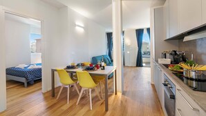Un appartement moderne comprenant un coin repas, une cuisine et une chambre.