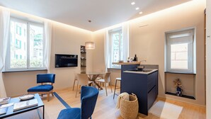 A modern living room with a sofa, a coffee table, a TV, and a dining area with chairs and a table. - A dreamlike apt in Piazzetta Portofino (Portofino)