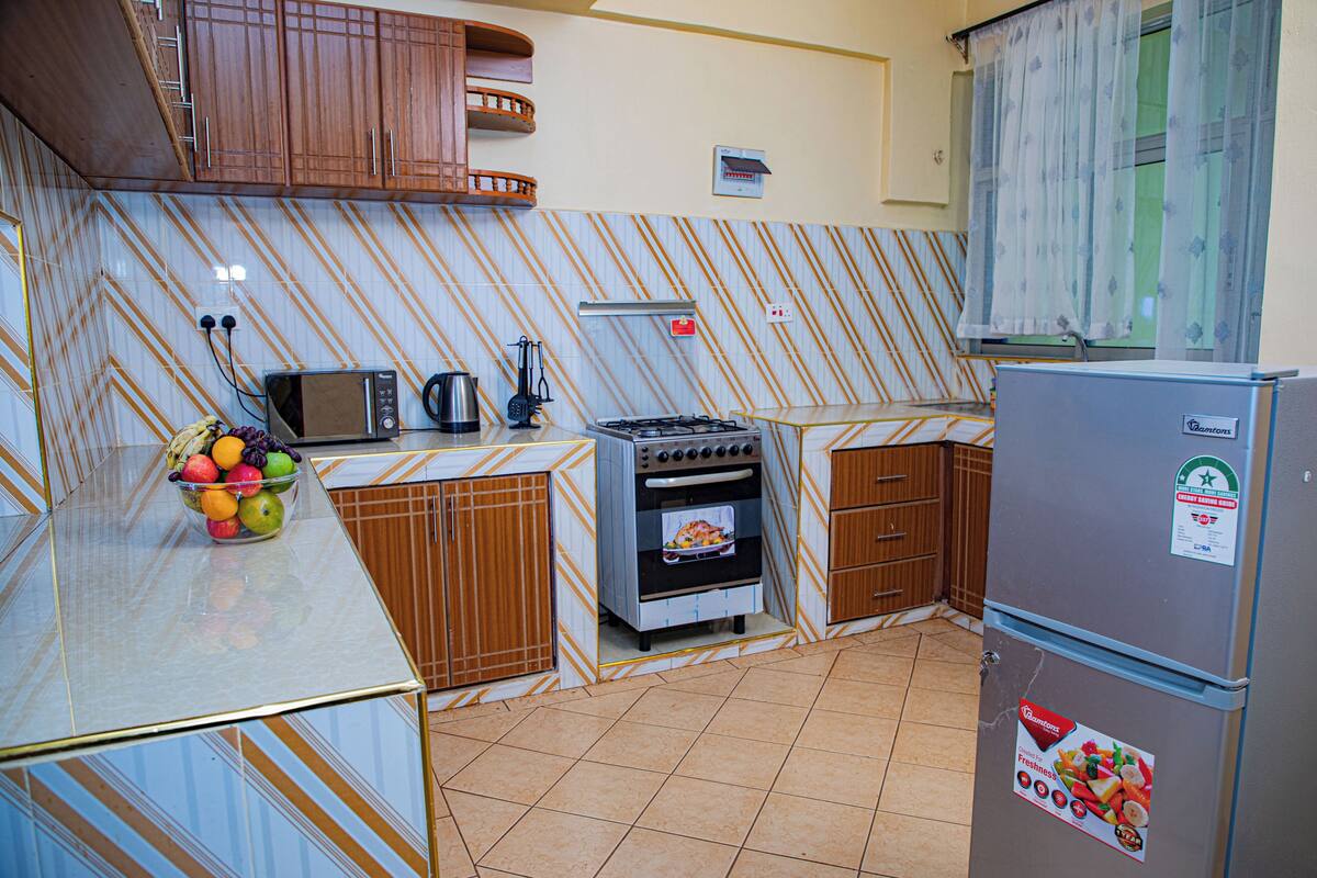 Una cocina equipada con microondas, estufa, horno y refrigerador.