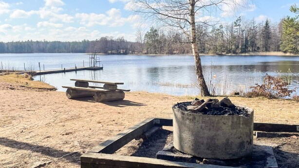 Caserío junto al lago con un hogar, mesa de picnic y muelle.