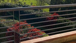 A balcony with a view of rolling hills and distant mountains.