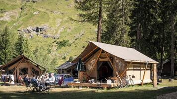 Un terrain de camping comprenant deux cabanes en bois, un espace repas et des vélos.