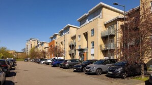 A row of modern apartment buildings with a parking lot in front. - 2 Bedrooms Apartment in Wembley (Wembley)