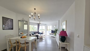 Un vaste espace de vie comprenant une table à manger, des chaises, un canapé et une grande fenêtre.