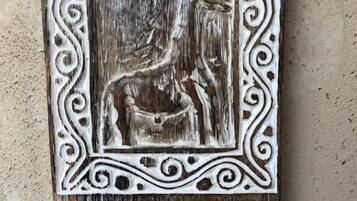 Eine rustikale Holztafel mit einer geschnitzten Holzfigur eines Reiters und einem Pferd, umgeben von aufwendigen Verzierungen, und der Zahl 2206.
