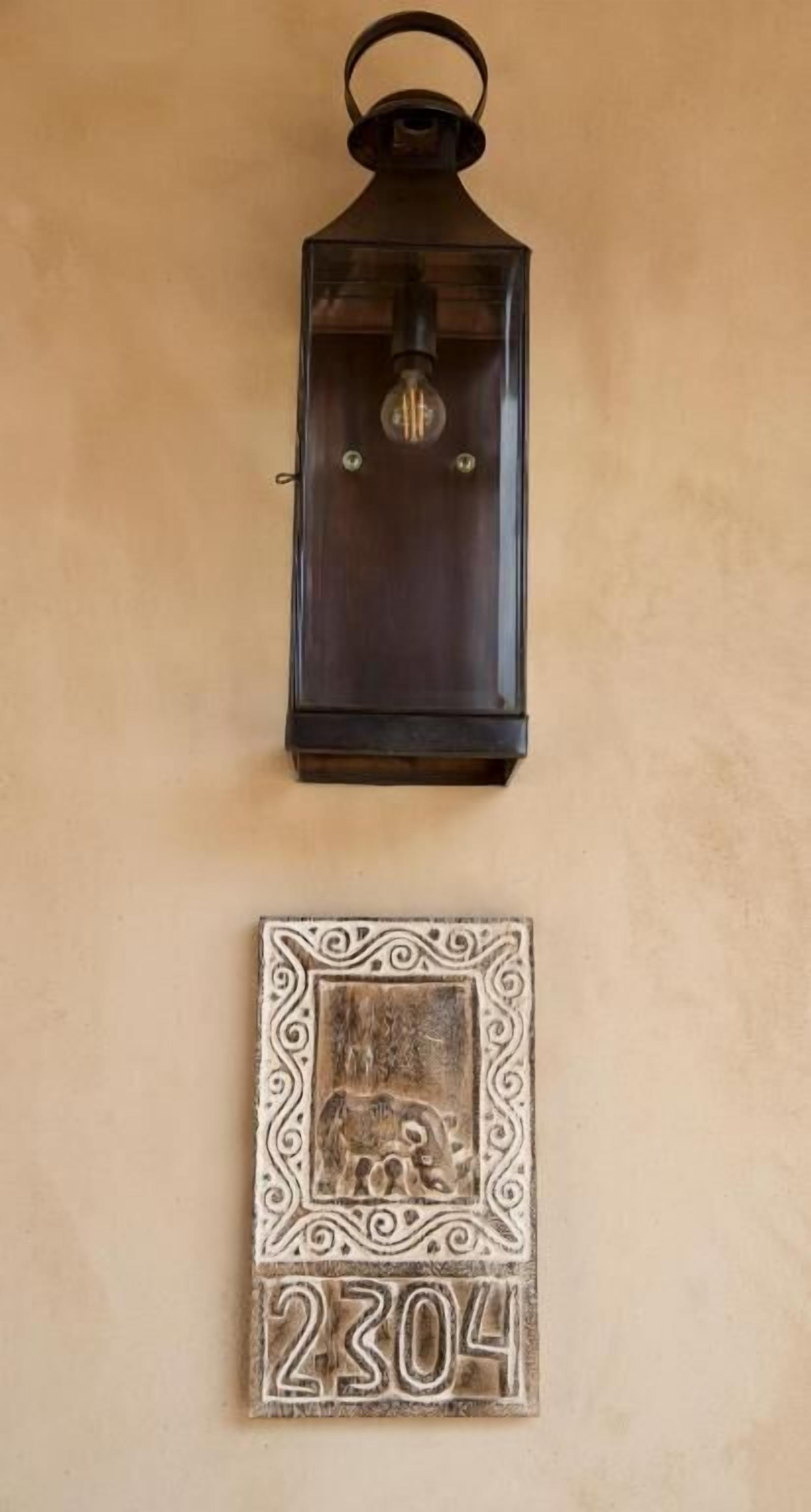 A wall-mounted lantern and a decorative plaque with the number 2304.