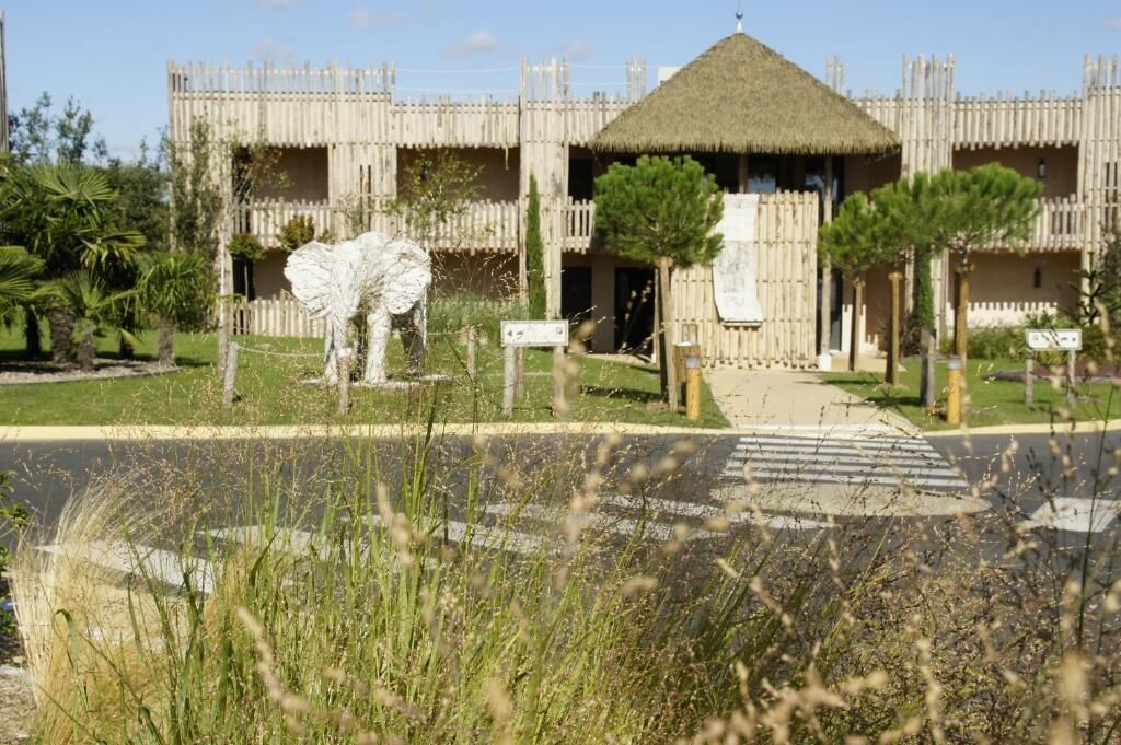 A building with a thatched roof and a fenced perimeter.
